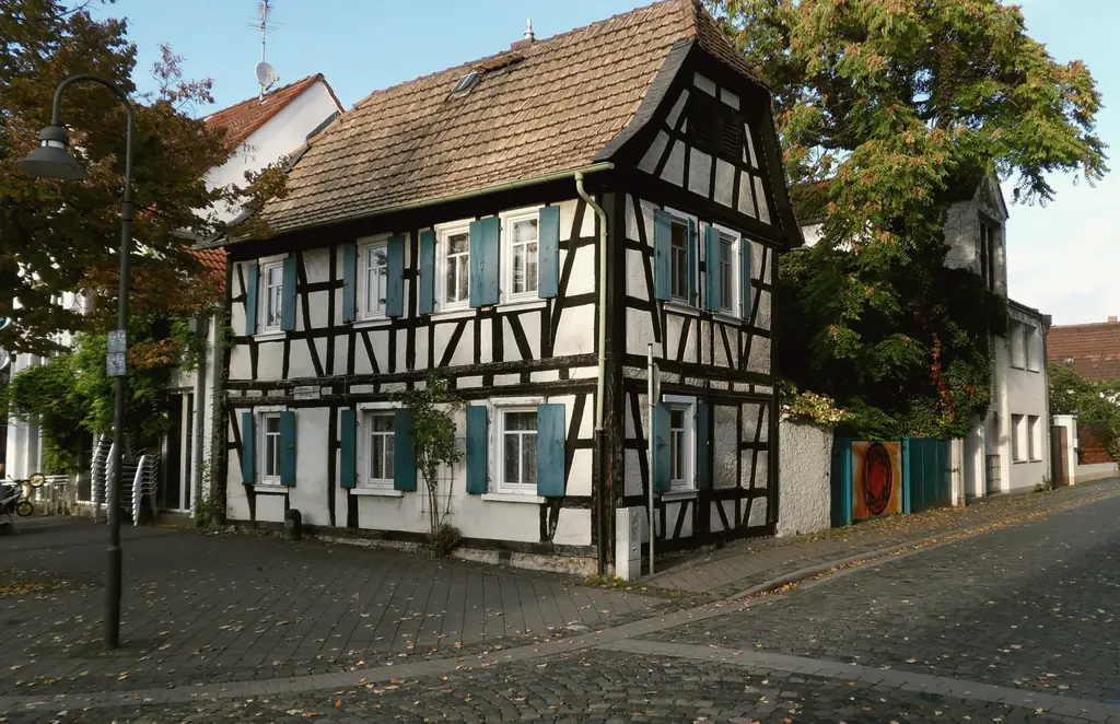 Schwarz-weißes Fachwerkhaus mit blauen Fensterläden in der Schäfergasse in der Altstadt von Rüsselsheim am Main.